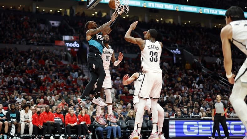Nov 17, 2022; Portland, Oregon, USA; Portland Trail Blazers point guard Damian Lillard (0) is fouled while shooting by Brooklyn Nets power forward Royce O'Neale (00) during the first half at Moda Center. Mandatory Credit: Soobum Im-USA TODAY Sports