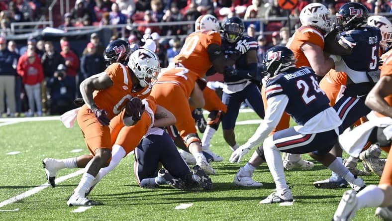 Nov 19, 2022; Lynchburg, Virginia, USA; Virginia Tech Hokies running back Jalen Holston (0 runs the ball  in the first half as Liberty Flames linebacker Aakil Washington (24) closes in at Williams Stadium. Mandatory Credit: Lee Luther Jr.-USA TODAY Sports