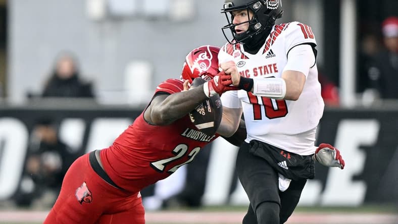 Nov 19, 2022; Louisville, Kentucky, USA; Louisville Cardinals linebacker Yasir Abdullah (22) sacks North Carolina State Wolfpack quarterback Ben Finley (10) during the second quarter at Cardinal Stadium. Mandatory Credit: Jamie Rhodes-USA TODAY Sports