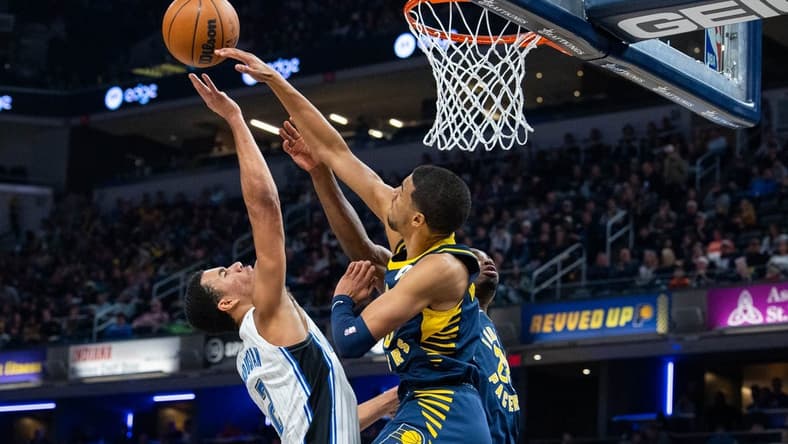 Nov 19, 2022; Indianapolis, Indiana, USA; Indiana Pacers guard Tyrese Haliburton (0) blocks a shot by Orlando Magic forward Caleb Houstan (2) in the second quarter at Gainbridge Fieldhouse. Mandatory Credit: Trevor Ruszkowski-USA TODAY Sports