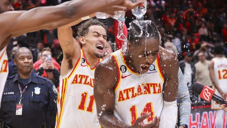Nov 19, 2022; Atlanta, Georgia, USA; Atlanta Hawks guard Trae Young (11) dumps water on forward AJ Griffin (14) after an overtime victory against the Toronto Raptors at State Farm Arena. Mandatory Credit: Brett Davis-USA TODAY Sports