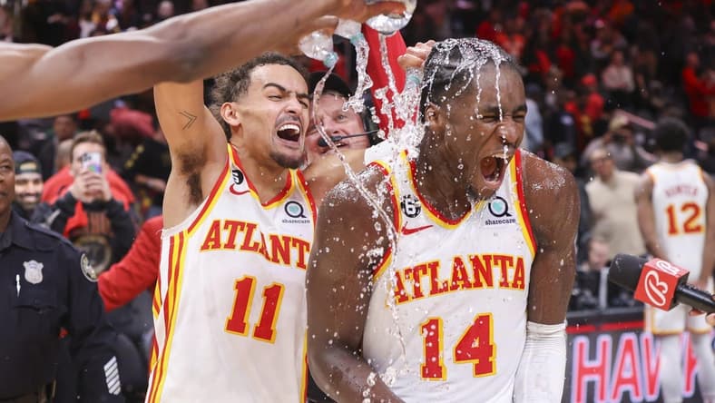 Nov 19, 2022; Atlanta, Georgia, USA; Atlanta Hawks guard Trae Young (11) dumps water on forward AJ Griffin (14) after an overtime victory against the Toronto Raptors at State Farm Arena. Mandatory Credit: Brett Davis-USA TODAY Sports