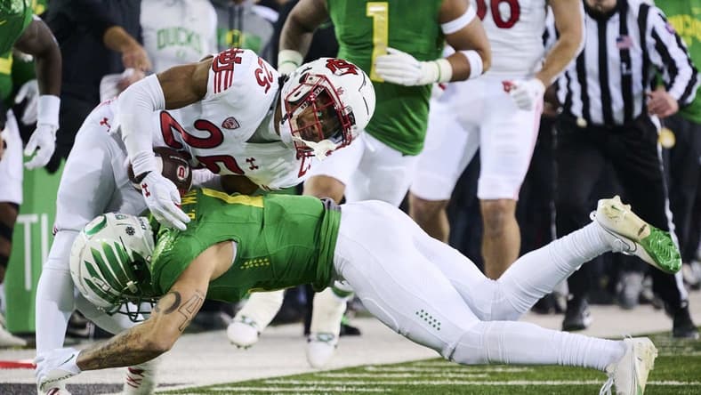 Nov 19, 2022; Eugene, Oregon, USA; Oregon Ducks defensive back Bennett Williams (4) tackles Utah Utes wide receiver Jaylen Dixon (25) during the first half at Autzen Stadium. Mandatory Credit: Troy Wayrynen-USA TODAY Sports