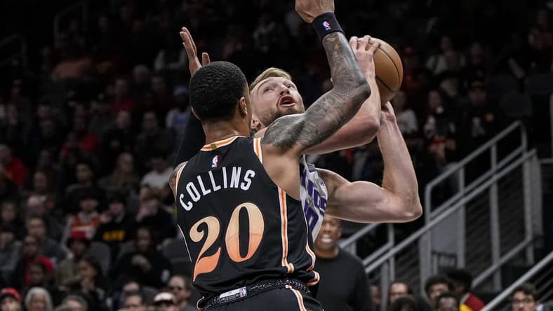 Nov 23, 2022; Atlanta, Georgia, USA; Sacramento Kings forward Domantas Sabonis (10) tries to shoot guarded by Atlanta Hawks forward John Collins (20) during the first half at State Farm Arena. Mandatory Credit: Dale Zanine-USA TODAY Sports