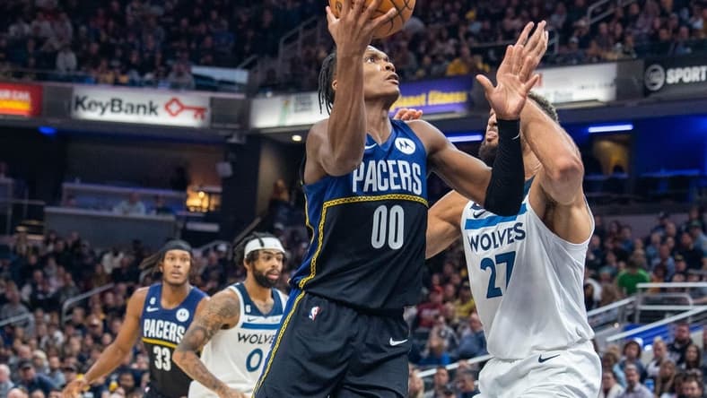 Nov 23, 2022; Indianapolis, Indiana, USA; Indiana Pacers guard Bennedict Mathurin (00) shoots the ball while Minnesota Timberwolves center Rudy Gobert (27) defends in the second half at Gainbridge Fieldhouse. Mandatory Credit: Trevor Ruszkowski-USA TODAY Sports