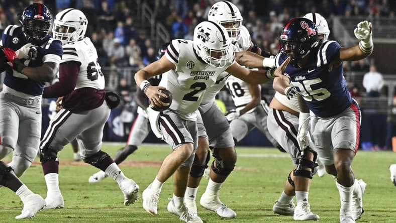 Nov 24, 2022; Oxford, Mississippi, USA; Mississippi State Bulldogs quarterback Will Rogers (2) moves in the pocket while defended by Ole Miss Rebels defensive end Tavius Robinson (95) during the first quarter at Vaught-Hemingway Stadium. Mandatory Credit: Matt Bush-USA TODAY Sports
