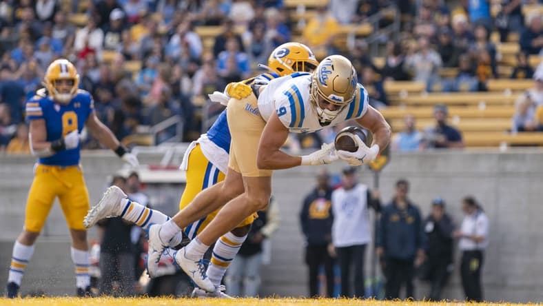 November 25, 2022; Berkeley, California, USA; UCLA Bruins wide receiver Jake Bobo (9) scores a touchdown against California Golden Bears safety Craig Woodson (2) during the first quarter at California Memorial Stadium. Mandatory Credit: Kyle Terada-USA TODAY Sports