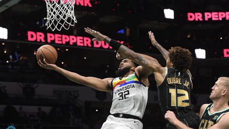 Nov 25, 2022; Charlotte, North Carolina, USA; Minnesota Timberwolves center Karl-Anthony Towns (32) drives as Charlotte Hornets forward Kelly Oubre Jr. (12) defends during the first half at the Spectrum Center. Mandatory Credit: Sam Sharpe-USA TODAY Sports