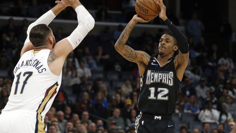 Nov 25, 2022; Memphis, Tennessee, USA; Memphis Grizzlies guard Ja Morant (12) shoots for three as New Orleans Pelicans center Jonas Valanciunas (17) defends during the first quarter at FedExForum. Mandatory Credit: Petre Thomas-USA TODAY Sports