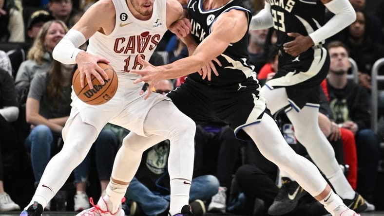 Nov 25, 2022; Milwaukee, Wisconsin, USA; Milwaukee Bucks guard Grayson Allen (12) reaches for the ball against Cleveland Cavaliers forward Cedi Osman (16) in the second quarter at Fiserv Forum. Mandatory Credit: Michael McLoone-USA TODAY Sports