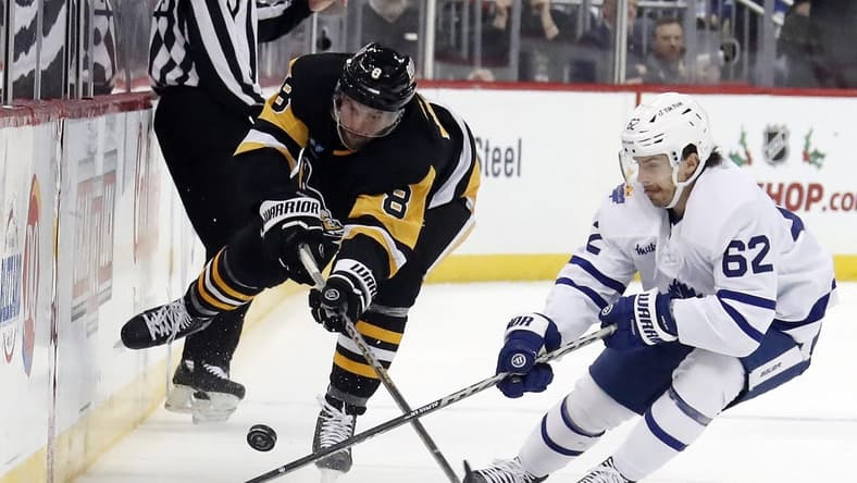 Nov 26, 2022; Pittsburgh, Pennsylvania, USA; Pittsburgh Penguins defenseman Brian Dumoulin (8) and Toronto Maple Leafs center Denis Malgin (62) battle for the puck during the second period at PPG Paints Arena. Toronto won 4-1. Mandatory Credit: Charles LeClaire-USA TODAY Sports