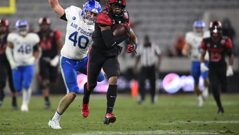 Nov 26, 2022; San Diego, California, USA; San Diego State Aztecs wide receiver Brionne Penny (11) runs with the ball as Air Force Falcons linebacker Alec Mock (40) prepares to punch the ball during the second half at Snapdragon Stadium. Mandatory Credit: Orlando Ramirez-USA TODAY Sports