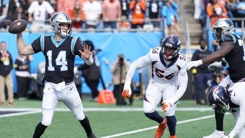 Nov 27, 2022; Charlotte, North Carolina, USA; Carolina Panthers quarterback Sam Darnold (14) throws under pressure from Denver Broncos linebacker Baron Browning (56) during the second quarter at Bank of America Stadium. Mandatory Credit: Jim Dedmon-USA TODAY Sports