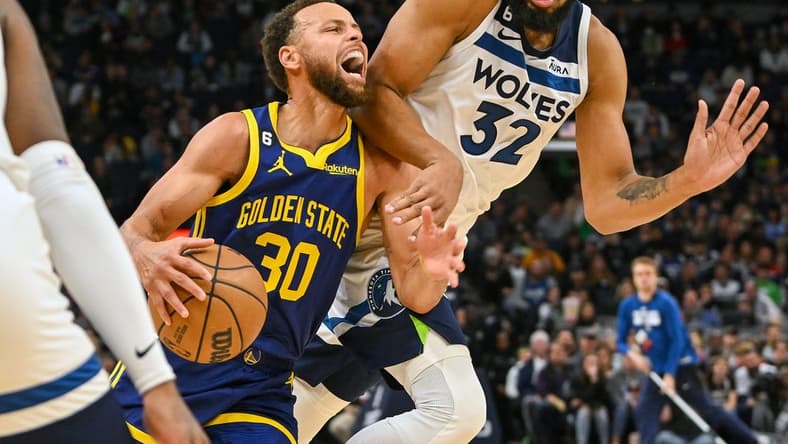 Nov 27, 2022; Minneapolis, Minnesota, USA; Golden State Warriors guard Stephen Curry (30) is called for traveling on this play with Minnesota Timberwolves center Karl-Anthony Towns (32) during the second quarter at Target Center. Mandatory Credit: Nick Wosika-USA TODAY Sports