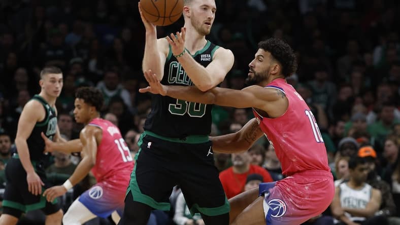 Nov 27, 2022; Boston, Massachusetts, USA; Boston Celtics forward Sam Hauser (30) looks to pass around Washington Wizards forward Anthony Gill (16) during the second half at TD Garden. Mandatory Credit: Winslow Townson-USA TODAY Sports