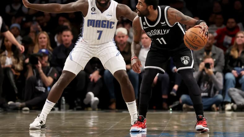 Nov 28, 2022; Brooklyn, New York, USA; Brooklyn Nets guard Kyrie Irving (11) controls the ball against Orlando Magic guard Kevon Harris (7) during the first quarter at Barclays Center. Mandatory Credit: Brad Penner-USA TODAY Sports