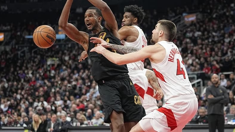 Nov 28, 2022; Toronto, Ontario, CAN; Toronto Raptors forward Juancho Hernangomez (41) and forward Thaddeus Young (21) knock the ball away from Cleveland Cavaliers forward Evan Mobley (4) during the first half at Scotiabank Arena. Mandatory Credit: John E. Sokolowski-USA TODAY Sports