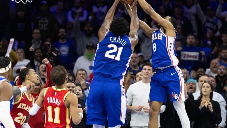 Nov 28, 2022; Philadelphia, Pennsylvania, USA; Philadelphia 76ers center Joel Embiid (21) gains control of the ball in front of Atlanta Hawks guard Trae Young (11) and forward John Collins (20) in the closing seconds of the fourth quarter at Wells Fargo Center. Mandatory Credit: Bill Streicher-USA TODAY Sports