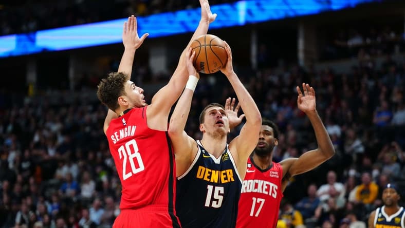 Nov 28, 2022; Denver, Colorado, USA; Denver Nuggets center Nikola Jokic (15) shoots past Houston Rockets center Alperen Sengun (28) in the second quarter at Ball Arena. Mandatory Credit: Ron Chenoy-USA TODAY Sports