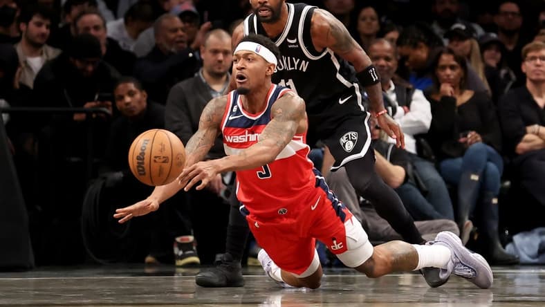 Nov 30, 2022; Brooklyn, New York, USA; Washington Wizards guard Bradley Beal (3) passes the ball as he falls away from Brooklyn Nets guard Kyrie Irving (11) during the second quarter at Barclays Center. Mandatory Credit: Brad Penner-USA TODAY Sports