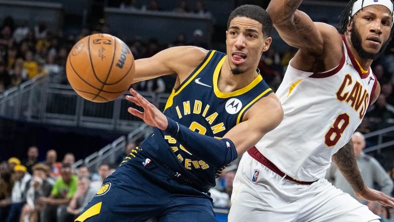 Mar 8, 2022; Indianapolis, Indiana, USA; Indiana Pacers guard Tyrese Haliburton (0) passes the ball while Cleveland Cavaliers forward Lamar Stevens (8) defends in the second half at Gainbridge Fieldhouse. Mandatory Credit: Trevor Ruszkowski-USA TODAY Sports