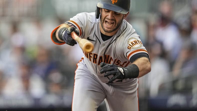 Jun 21, 2022; Cumberland, Georgia, USA; San Francisco Giants designated hitter Tommy La Stella (8) reacts after being hit by a pitch prior to scoring against the Atlanta Braves during the second inning at Truist Park. Mandatory Credit: Dale Zanine-USA TODAY Sports