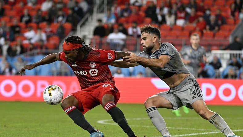 Sep 4, 2022; Toronto, Ontario, CAN; Toronto FC forward Ifunanyachi Achara (99) tries to get away from CF Montreal defender Rudy Camacho (4) in the second half at BMO Field. Mandatory Credit: Dan Hamilton-USA TODAY Sports