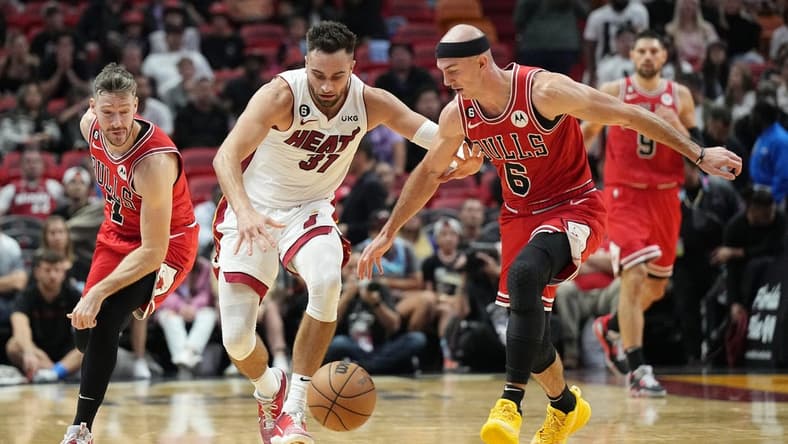 Oct 19, 2022; Miami, Florida, USA; Chicago Bulls guard Goran Dragic (7) tips the ball away from Miami Heat guard Max Strus (31) as guard Alex Caruso (6) follows on the play in the second half at FTX Arena. Mandatory Credit: Jim Rassol-USA TODAY Sports