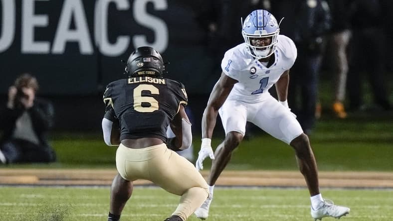 Nov 12, 2022; Winston-Salem, North Carolina, USA; Wake Forest Demon Deacons running back Justice Ellison (6) tries to evade North Carolina Tar Heels defensive back Tony Grimes (1) during the second half at Truist Field. Mandatory Credit: Jim Dedmon-USA TODAY Sports
