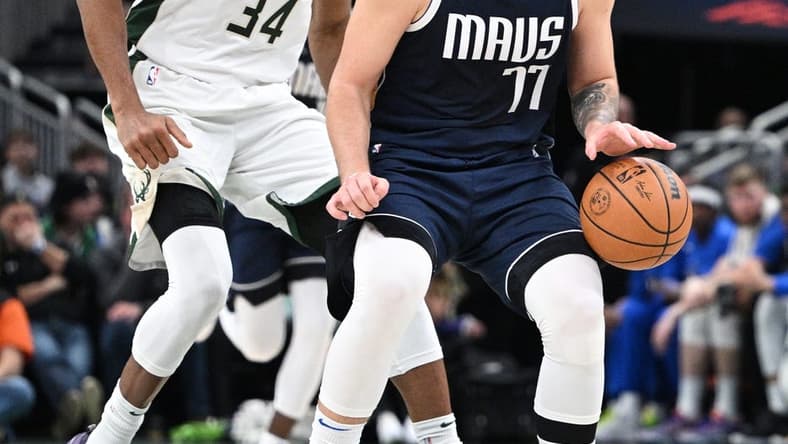 Dallas Mavericks guard Luka Doncic (77) dribbles the ball up court against Milwaukee Bucks forward Giannis Antetokounmpo (34) in the second half at Fiserv Forum. Mandatory Credit: Michael McLoone-USA TODAY Sports