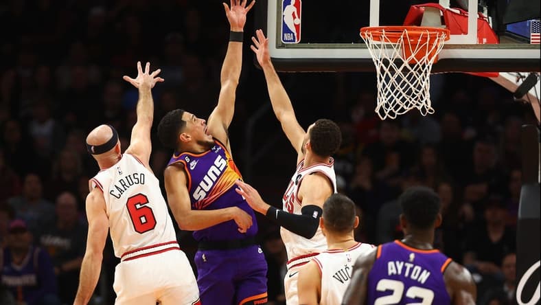 Nov 30, 2022; Phoenix, Arizona, USA; Phoenix Suns guard Devin Booker (1) shoots against Chicago Bulls guard Zach LaVine (8) and guard Alex Caruso (6) during the first half  at Footprint Center. Mandatory Credit: Mark J. Rebilas-USA TODAY Sports
