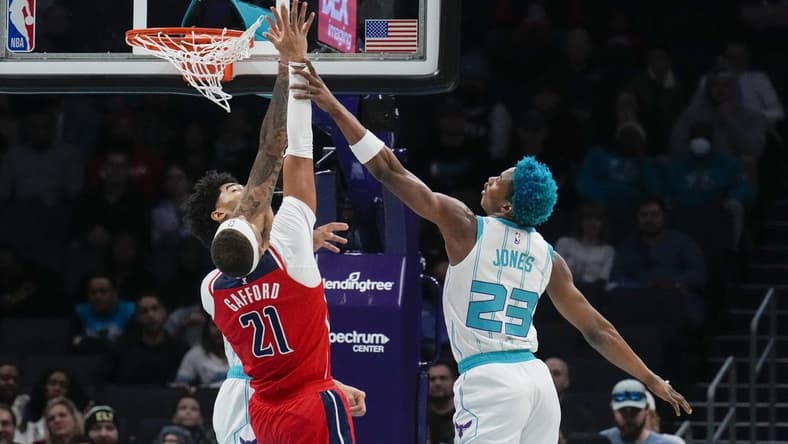 Dec 2, 2022; Charlotte, North Carolina, USA; Charlotte Hornets center Nick Richards (4) and forward Kai Jones (23) try for a block on Washington Wizards center Daniel Gafford (21) during the first quarter at Spectrum Center. Mandatory Credit: Jim Dedmon-USA TODAY Sports