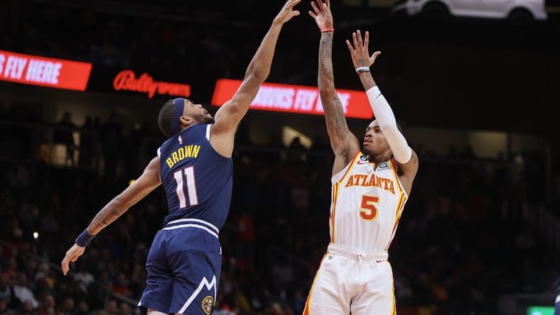 Dec 2, 2022; Atlanta, Georgia, USA; Atlanta Hawks guard Dejounte Murray (5) shoots over Denver Nuggets forward Bruce Brown (11) in the second quarter at State Farm Arena. Mandatory Credit: Brett Davis-USA TODAY Sports