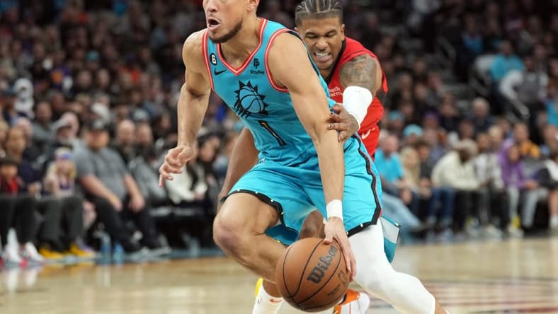 Dec 2, 2022; Phoenix, Arizona, USA; Phoenix Suns guard Devin Booker (1) dribbles by Houston Rockets guard Jalen Green (4) during the second half at Footprint Center. Mandatory Credit: Joe Camporeale-USA TODAY Sports