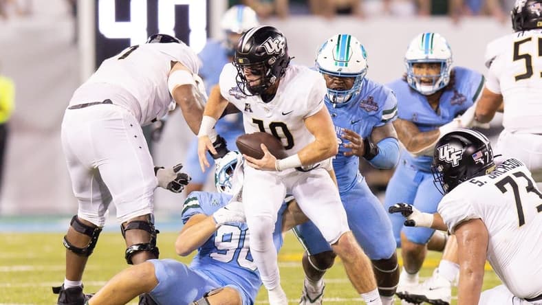 Dec 3, 2022; New Orleans, Louisiana, USA; UCF Knights quarterback John Rhys Plumlee (10) scrambles away from Tulane Green Wave defensive lineman Patrick Jenkins (0) during the second half at Yulman Stadium. Mandatory Credit: Stephen Lew-USA TODAY Sports