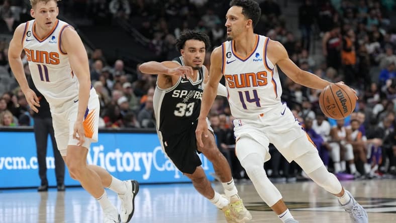 Dec 4, 2022; San Antonio, Texas, USA; Phoenix Suns guard Landry Shamet (14) dribbles past San Antonio Spurs guard Tre Jones (33) in the first half at the AT&T Center. Mandatory Credit: Daniel Dunn-USA TODAY Sports