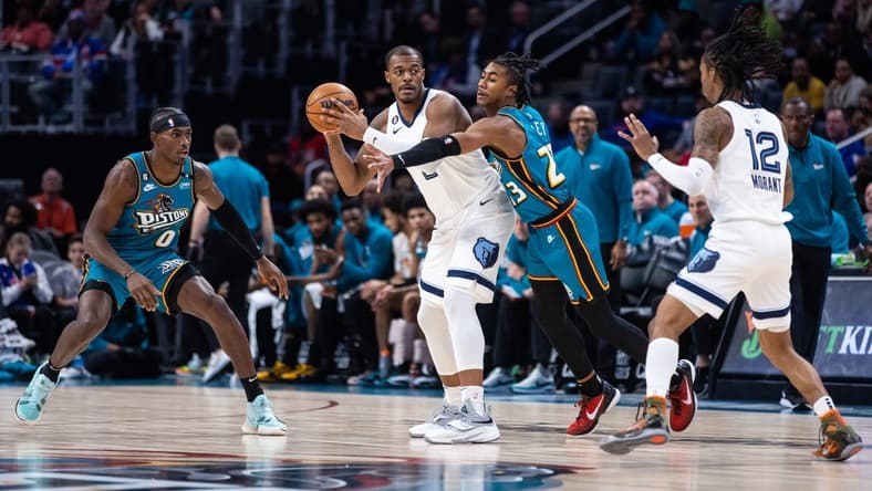 Dec 4, 2022; Detroit, Michigan, USA; Memphis Grizzlies forward Xavier Tillman Sr. (2) passes the ball through coverage by Detroit Pistons guard Jaden Ivey (23) in the first quarter at Little Caesars Arena. Mandatory Credit: Allison Farrand-USA TODAY Sports
