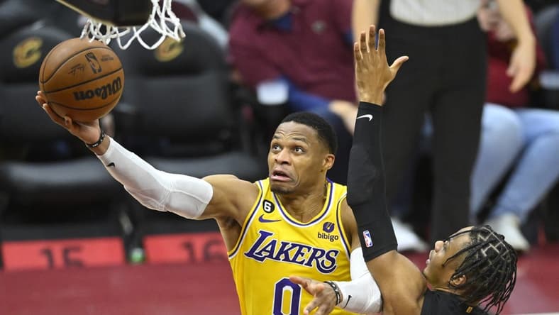 Dec 6, 2022; Cleveland, Ohio, USA; Los Angeles Lakers guard Russell Westbrook (0) drives against Cleveland Cavaliers forward Isaac Okoro (35) in the fourth quarter at Rocket Mortgage FieldHouse. Mandatory Credit: David Richard-USA TODAY Sports