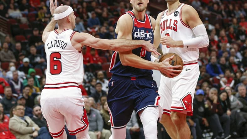 Dec 7, 2022; Chicago, Illinois, USA; Washington Wizards center Kristaps Porzingis (6) drives to the basket against Chicago Bulls guard Alex Caruso (6) during the first half at United Center. Mandatory Credit: Kamil Krzaczynski-USA TODAY Sports