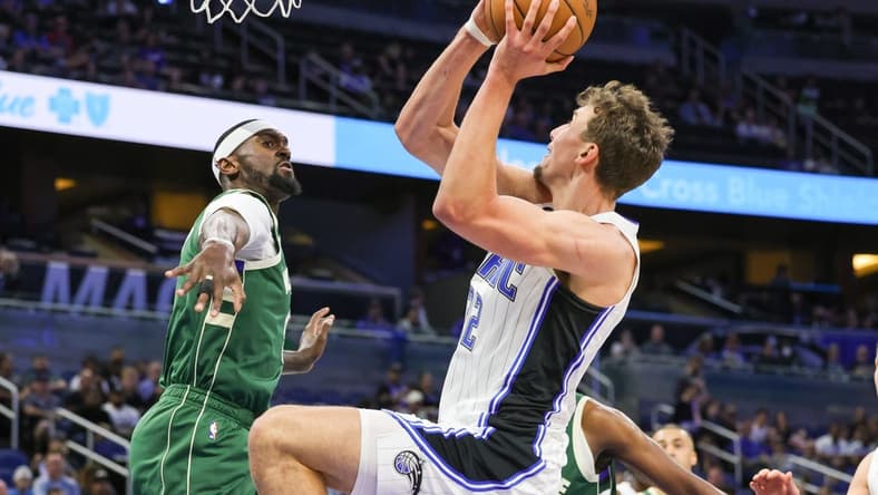 Dec 5, 2022; Orlando, Florida, USA; Orlando Magic forward Franz Wagner (22) is fouled by Milwaukee Bucks forward Bobby Portis (9) during the first quarter at Amway Center. Mandatory Credit: Mike Watters-USA TODAY Sports