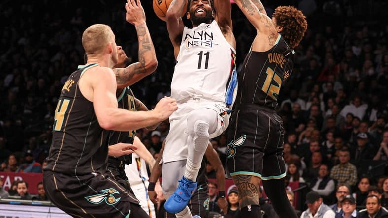 Dec 7, 2022; Brooklyn, New York, USA; Brooklyn Nets guard Kyrie Irving (11) drives to the basket as Charlotte Hornets guard Kelly Oubre Jr. (12) and center Mason Plumlee (24) defend during the second half at Barclays Center. Mandatory Credit: Vincent Carchietta-USA TODAY Sports