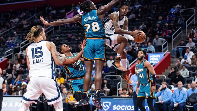Dec 4, 2022; Detroit, Michigan, USA; Memphis Grizzlies guard Ja Morant (12) passes the ball around Detroit Pistons center Isaiah Stewart (28) in the second half at Little Caesars Arena. Mandatory Credit: Allison Farrand-USA TODAY Sports