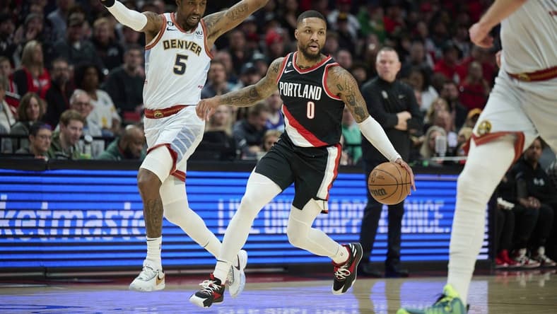 Dec 8, 2022; Portland, Oregon, USA; Portland Trail Blazers guard Damian Lillard (0) drives to the basket during the first half against Denver Nuggets guard Kentavious Caldwell-Pope (5) at Moda Center. Mandatory Credit: Troy Wayrynen-USA TODAY Sports