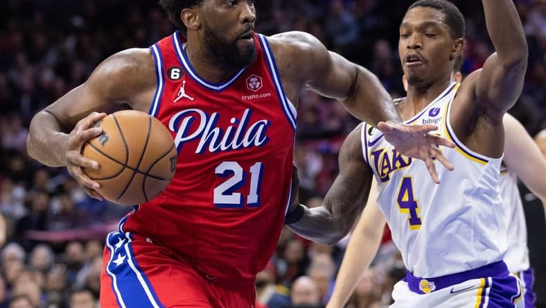 Dec 9, 2022; Philadelphia, Pennsylvania, USA; Philadelphia 76ers center Joel Embiid (21) drives past Los Angeles Lakers guard Lonnie Walker IV (4) during the first quarter at Wells Fargo Center. Mandatory Credit: Bill Streicher-USA TODAY Sports