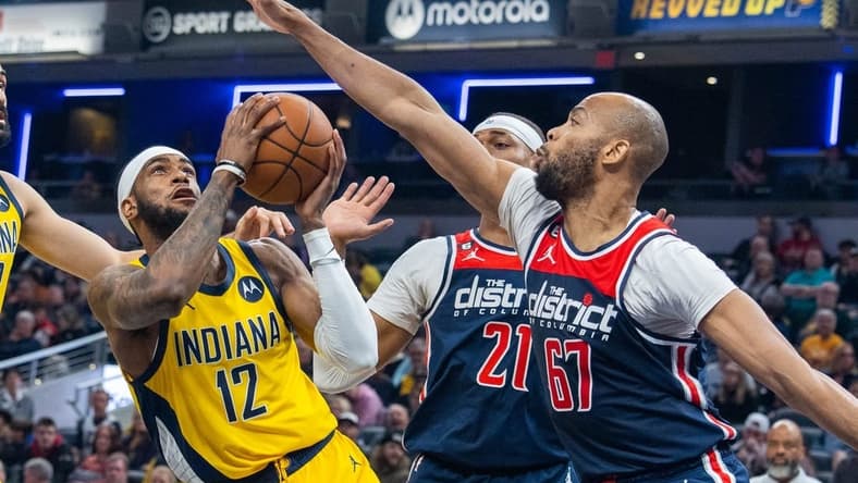 Dec 9, 2022; Indianapolis, Indiana, USA; Indiana Pacers forward Oshae Brissett (12) shoots the ball while Washington Wizards forward Taj Gibson (67) defends in the second quarter at Gainbridge Fieldhouse. Mandatory Credit: Trevor Ruszkowski-USA TODAY Sports