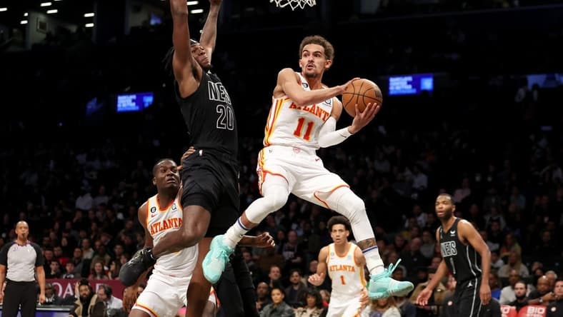Dec 9, 2022; Brooklyn, New York, USA; Atlanta Hawks guard Trae Young (11) looks to pass the ball around Brooklyn Nets center Day'Ron Sharpe (20) during the second quarter at Barclays Center. Mandatory Credit: Brad Penner-USA TODAY Sports