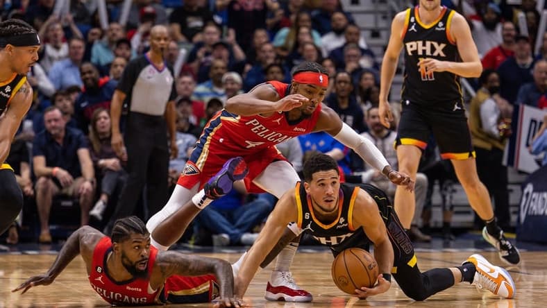 Dec 9, 2022; New Orleans, Louisiana, USA; Phoenix Suns guard Devin Booker (1) and New Orleans Pelicans forward Naji Marshall (8) fight for a loose ball on the court during the first half at Smoothie King Center. Mandatory Credit: Stephen Lew-USA TODAY Sports