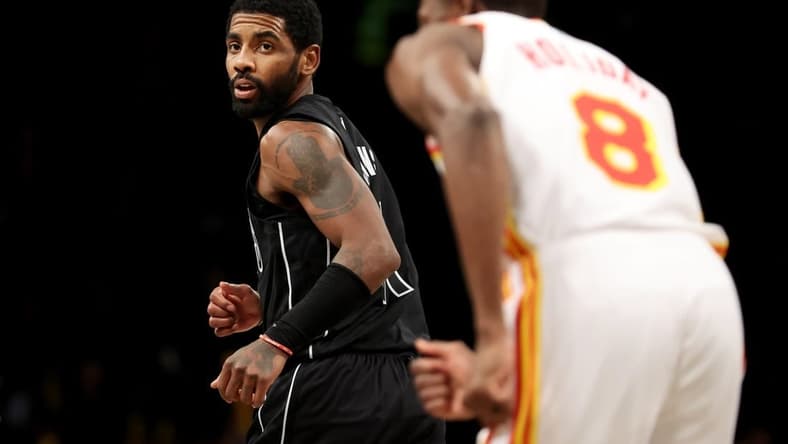 Dec 9, 2022; Brooklyn, New York, USA; Brooklyn Nets guard Kyrie Irving (11) looks back after a basket against Atlanta Hawks forward Justin Holiday (8) during the fourth quarter at Barclays Center. Mandatory Credit: Brad Penner-USA TODAY Sports