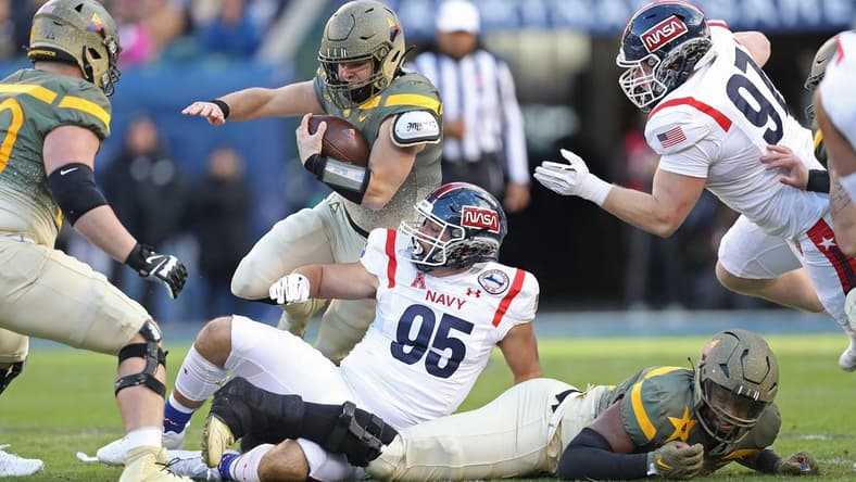 Dec 10, 2022; Philadelphia, Pennsylvania, USA; Army Black Knights quarterback Cade Ballard (18) carries the ball over Navy Midshipmen lineman Jacob Busic (95) during the first half of the 123rd Army-Navy game at Lincoln Financial Field. Mandatory Credit: Danny Wild-USA Today Sports