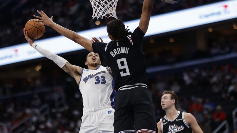 Dec 10, 2022; Washington, District of Columbia, USA; Washington Wizards forward Kyle Kuzma (33) shoots the ball as Los Angeles Clippers forward Moses Brown (9) defends in the second quarter at Capital One Arena. Mandatory Credit: Geoff Burke-USA TODAY Sports